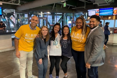 Picture of YWCA staff and GenRising members posing at a Seattle Mariners Game during YWCA's 125th anniversary celebrations