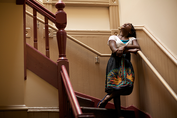 A young Black girl looking up a staircase