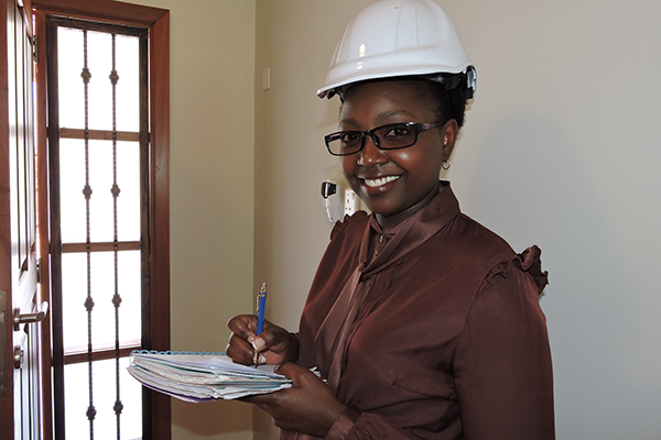 A woman in a hardhat holds an engineering inspection list