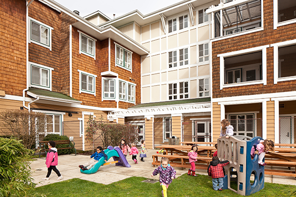 Children are pictured playing in front of a Family Village