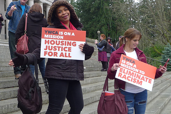 Advocates stand with signs on the steps of Washington's Capitol Building