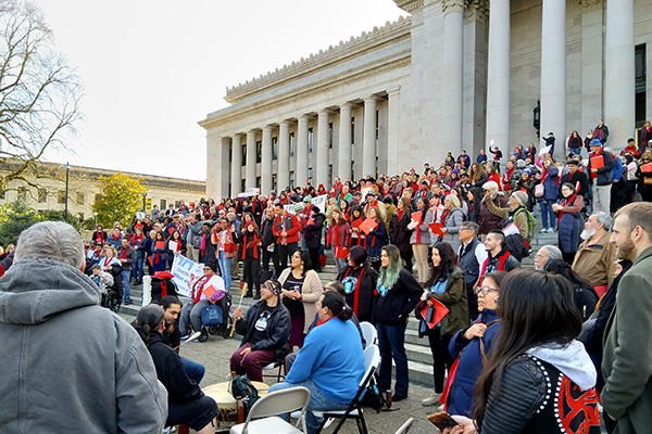 Advocates stand with signs on the steps of Washington's Capitol Building