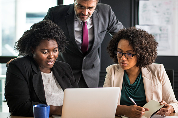 Two black women work in an office. Image from rawpixel.com