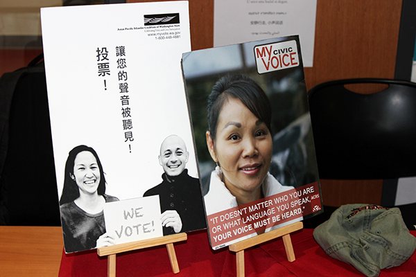 A booth by Asian Counseling and Referal Service registering people to vote in multiple languages