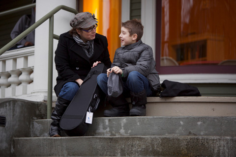 A woman and her child sit on their stoop