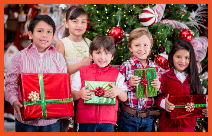 A photo of five children holding presents and looking at the camera