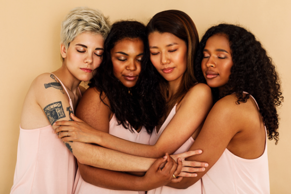 Picture of a white woman, an Asian woman, and two Black women embracing