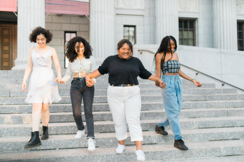 Picture of four multicultural girls walking down building steps