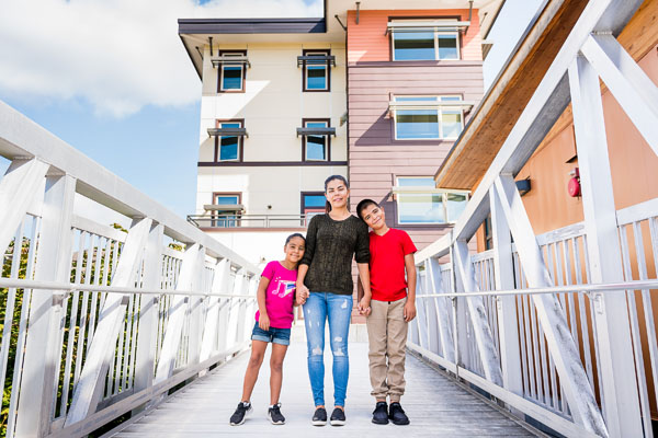 Family stands on the pedestrian bridge at YWCA Family Village Issaquah