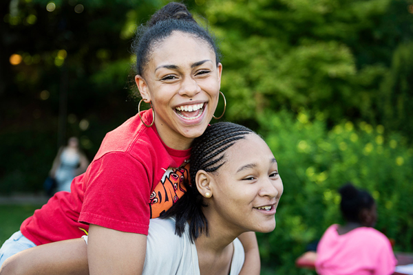 Two girls run in a relay race at school