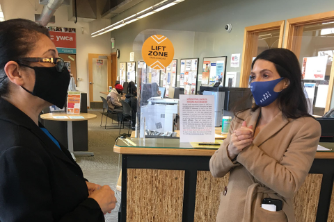 Picture of YWCA and Comcast staff standing in front of a sticker that says "lift zone" on it