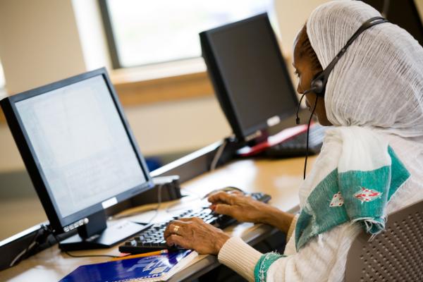 A Black woman works at a computer at YWCA's Greenbridge Center