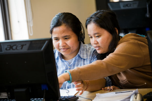 Two women work on a computer at YWCA Greenbridge