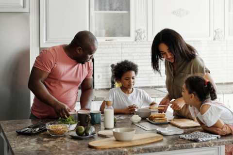Picture of a Black family gathered in a kitchen