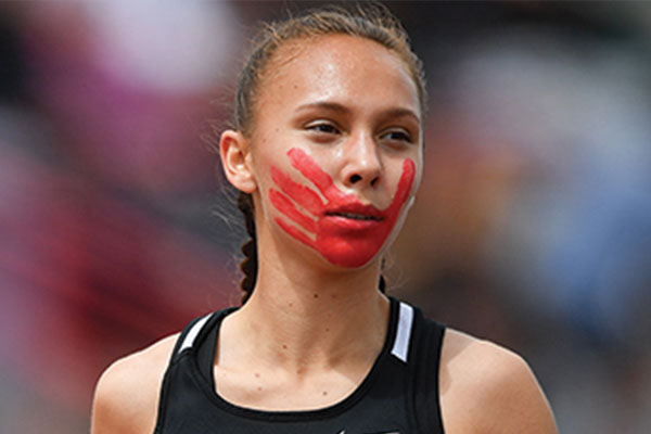 Picture of Rosalie Fish at a track meet with a red hand painted over her face