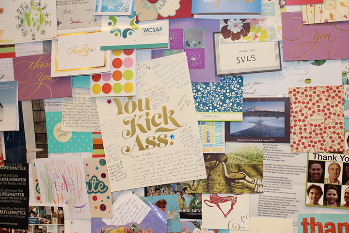 A wall of thank you cards in the office is shown.