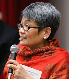 A portrait photo of Velma Veloria in a red scarf