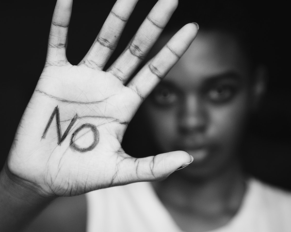 A black woman with "NO" written on her hand