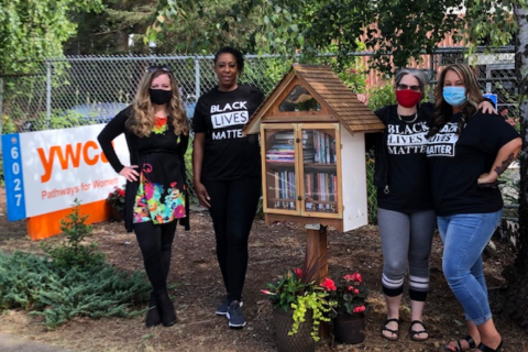 Picture of YWCA staff posing by Little Free Library in Black Lives Matter shirts