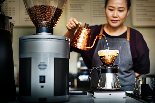 A woman makes coffee at a cafe