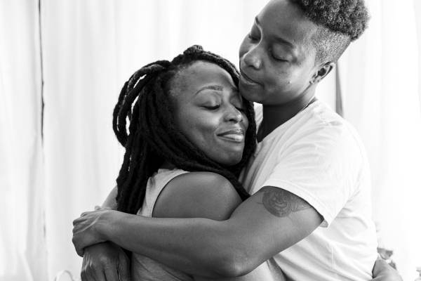 A transgender man and his partner share a hug