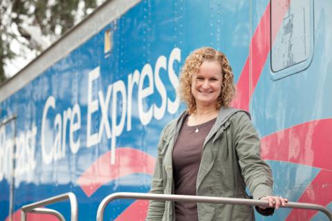 A patient poses in from of the "Breast Care Express" mobile clinic