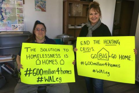 Mindy Woods holds a march sign advocating for more homes.