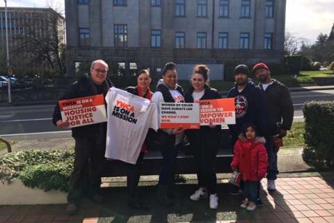 Advocates stand with YWCA signs and t-shirts